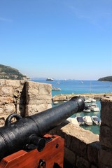 Fototapeta na wymiar Loophole and old cannon on the fortress wall in Dubrovnik, Croatia.