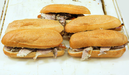 five sandwiches stuffed with roast pork for sale in the food sta