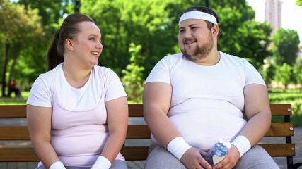 Obese insecure people laughing together, good mood as support in difficult times
