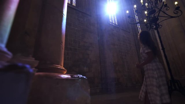 Colored sun shining from stained glass window illuminated interior and columns inside ancient cathedral in Portugal