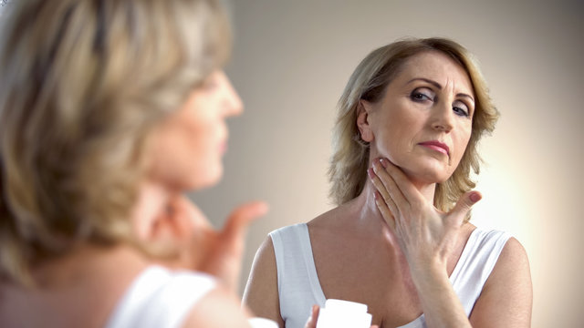 Elderly Lady Applying Anti-age Cream On Neck, Skin Care In Old Age, Wrinkles