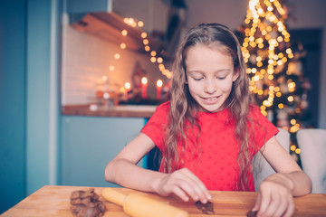 Adorable little girl baking Christmas gingerbread cookies