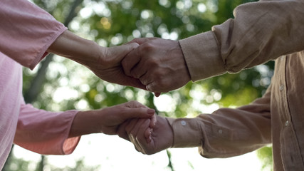 Senior couple holding hands, meeting old age together, close relationship, care
