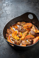 Traditional Iranian khoresh beh stew with chunks of lamb and quinces as top view in a modern style Japanese cast-iron roasting dish