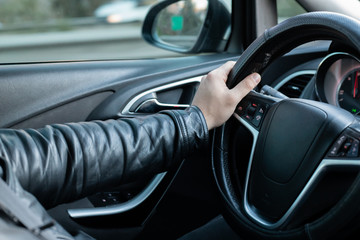 Male driver holding steering wheel while driving