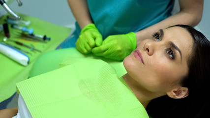 Female patient waiting for teeth polishing procedure in chair, regular check-up