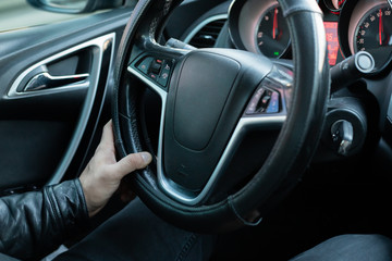 Male driver holding steering wheel while driving