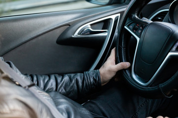 Male driver holding steering wheel while driving
