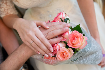 Obraz na płótnie Canvas Bride and groom hands with gold wedding rings
