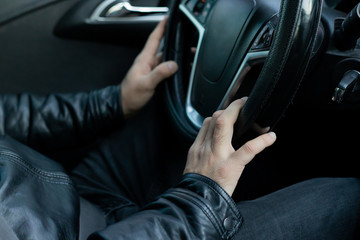 Male driver holding steering wheel while driving