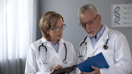 Fototapeta premium Colleagues comparing results, male and female doctors consulting on diagnosis
