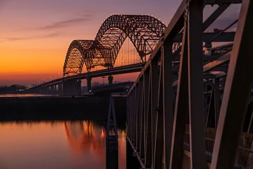 Fotobehang Zonsondergang op de Mississippi-rivier bij de Memphis-brug © The Speedy Butterfly