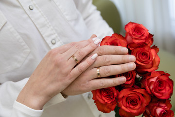 Obraz na płótnie Canvas Bride and groom hands with gold wedding rings