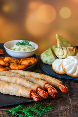Giant king prawns and selection of mini Chinese dumplings with yogurt dipping sauces. Party food idea.