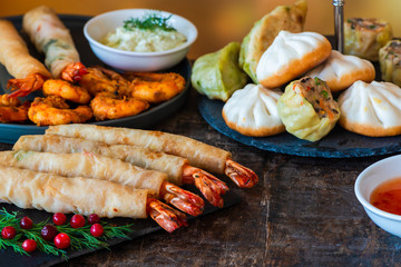 Giant king prawns and selection of mini Chinese dumplings with sweet chili and yogurt dipping sauces. Party food idea.