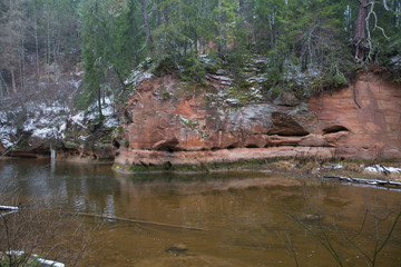 Red cliffs and river in winter. Snow and rocks, travel photo 2018