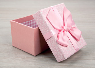 open pink gift box on wooden background