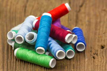 spools of thread on a wooden background