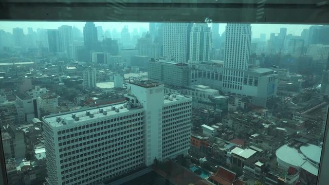 View on Bangkok city from moving up elevator in skyscraper, Thailand, 4k