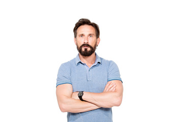 Puzzled bearded man keeping his arms crossed