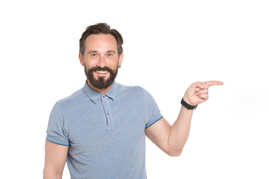 Delighted middle aged man in casual clothes pointing sideways