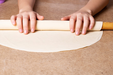 woman hands holding rolling pin on dough