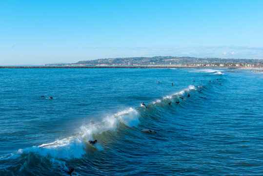 People surfing in the sea with clear blue sky