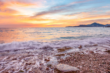 Obraz premium Vibrant sunset at the beach - in Sveti Stefan