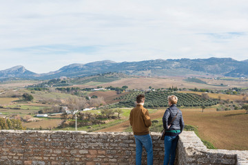 Fototapeta na wymiar Dos personas observan el paisaje desde un mirador