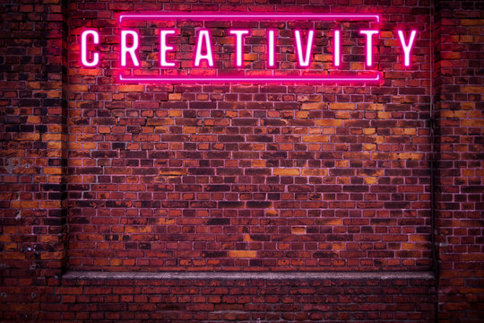 Magenta Creativity Neon Sign On Red Brick Wall