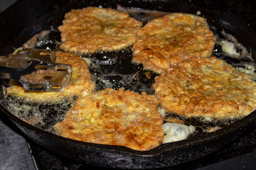 Orange draniki with cabbage fried in a frying pan close-up