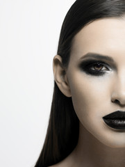 Naklejka premium Black and white photograph of the terrible beauty of the model, like from a horror movie. Party party, Halloween, creative make-up, smoky eyes and full lips
