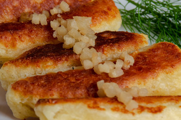 Fried cheese and kefir sticks served in white plate. Made from cheese, flour and kefir. Close up.