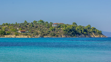 tropic island coast in park trees natural environment and apartment house near to beach in Mediterranean sea vivid  blue water lagoon 