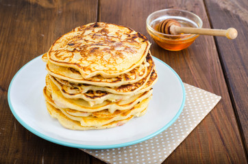 White plate with pancakes on wooden table