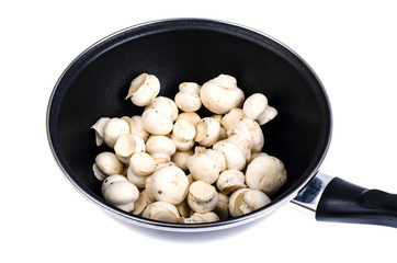 Pan with raw fresh champignons isolated on white background