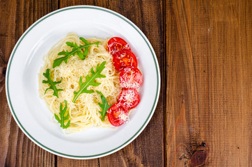 Spaghetti with cheese, tomatoes and arugula