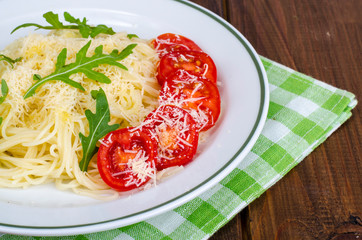 Spaghetti with cheese, tomatoes and arugula