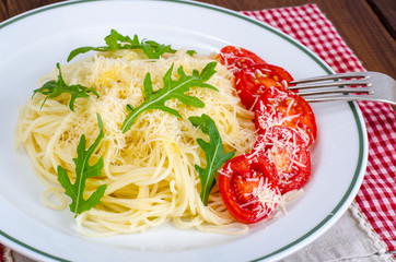 Spaghetti with cheese, tomatoes and arugula