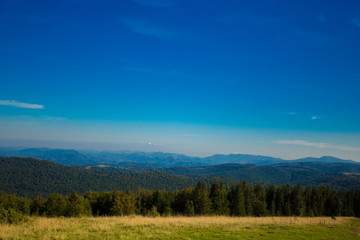 Beautiful landscape of summer mountains with blue sky. Autumn mountain village panoramic landscape