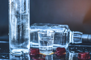 Vodka bottle with glasses and a red ice, vodka and whiskey in glass with ice, alcoholic drink