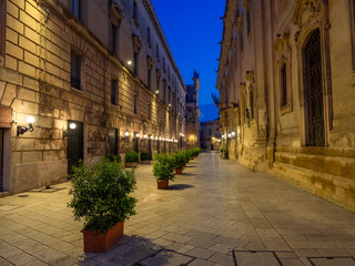 Fototapeta na wymiar Traditional historic architecture in Lecce city early in the morning, illuminated square and old houses in Italy
