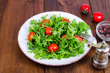 Plate with light dietary salad of arugula and cherry tomatoes