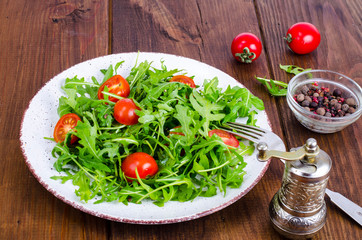 Plate with light dietary salad of arugula and cherry tomatoes