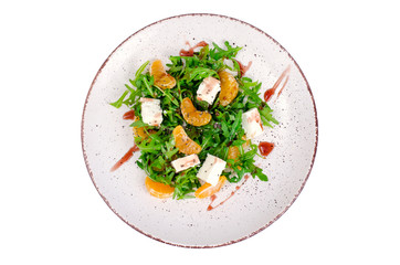 Delicious fruit and vegetables salad. Tangerine, feta cheese, arugula and chia seeds in plate. Healthy food concept