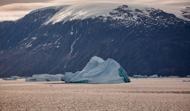 lanfscape with iceberg among fjords at sunset