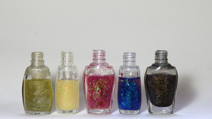 Bottle of colorful glittering nail polish. Space in blank to insert text about nail polish, vanity, beauty, trends