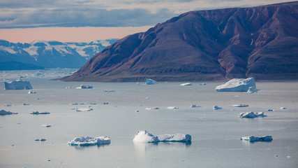 arctic landscape with icebergs among east Greenland fjords