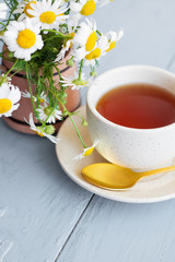 cup of herbal chamomile tea with fresh daisy flowers on wooden background. doctor treatment and prevention of immune concept, medicine - folk, alternative, complementary, traditional medicine 