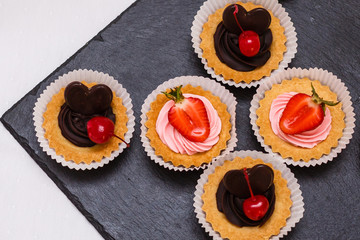 Delicious chocolate cupcakes with berries on white table, top view